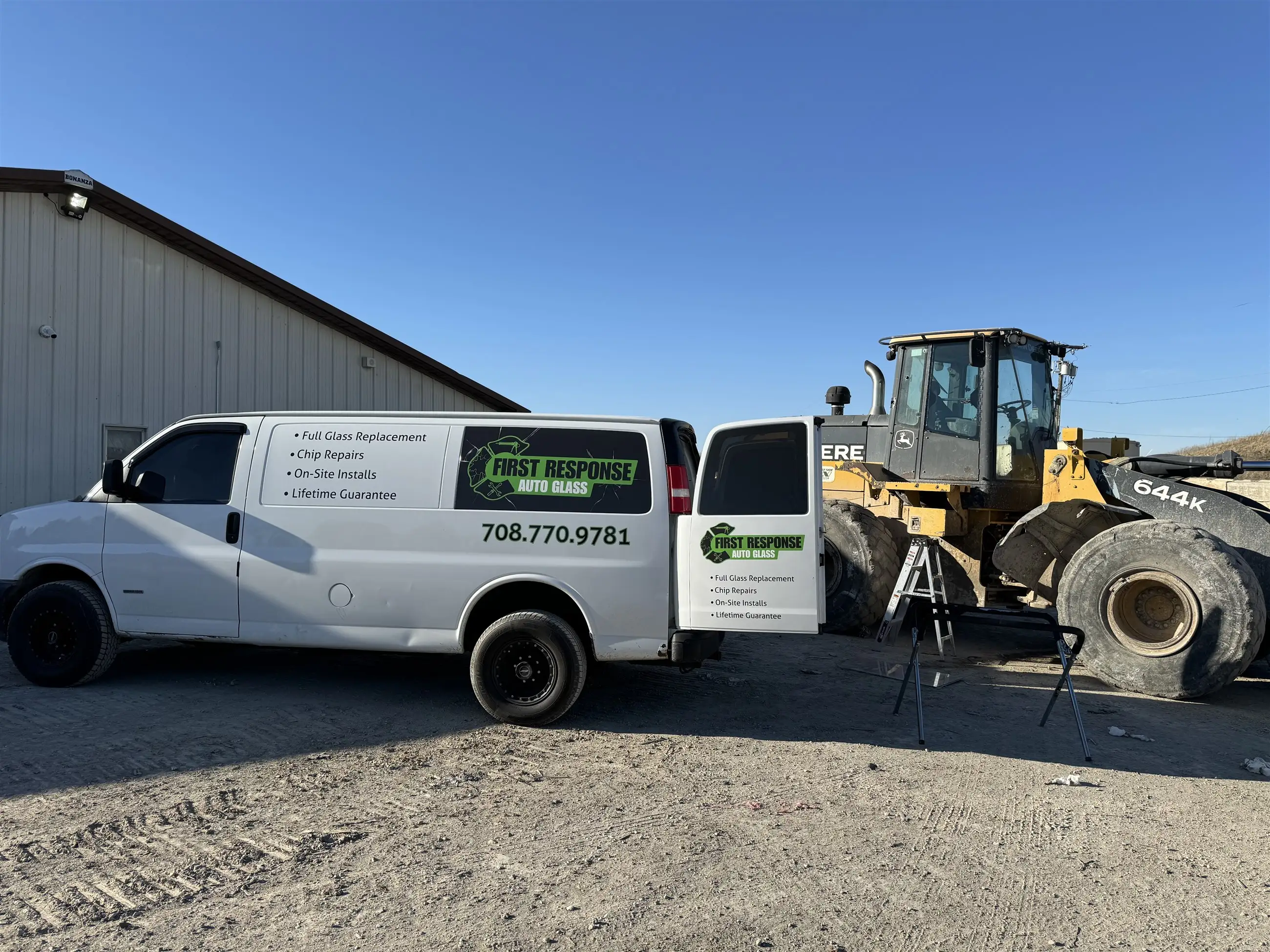 First Response Auto Glass mobile van beside a wheel loader at a jobsite in the SW Chicago suburbs